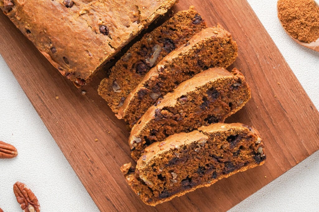 slices of pumpkin bread with chocolate chips on a bread board .