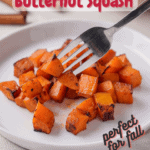 Air fried butternut squash on a white plate with a fork taking a few pieces with Pinterest text overlay.