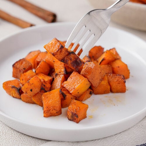 Using a fork to take some pieces of air fried butternut squash.