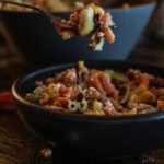 Taking a forkful of fall pasta salad from the bowl.