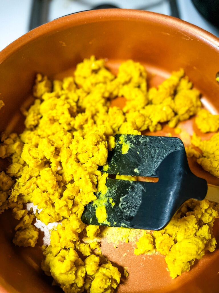 Scrambling mung bean eggs. Showing the spatula cutting the cooked pieces.