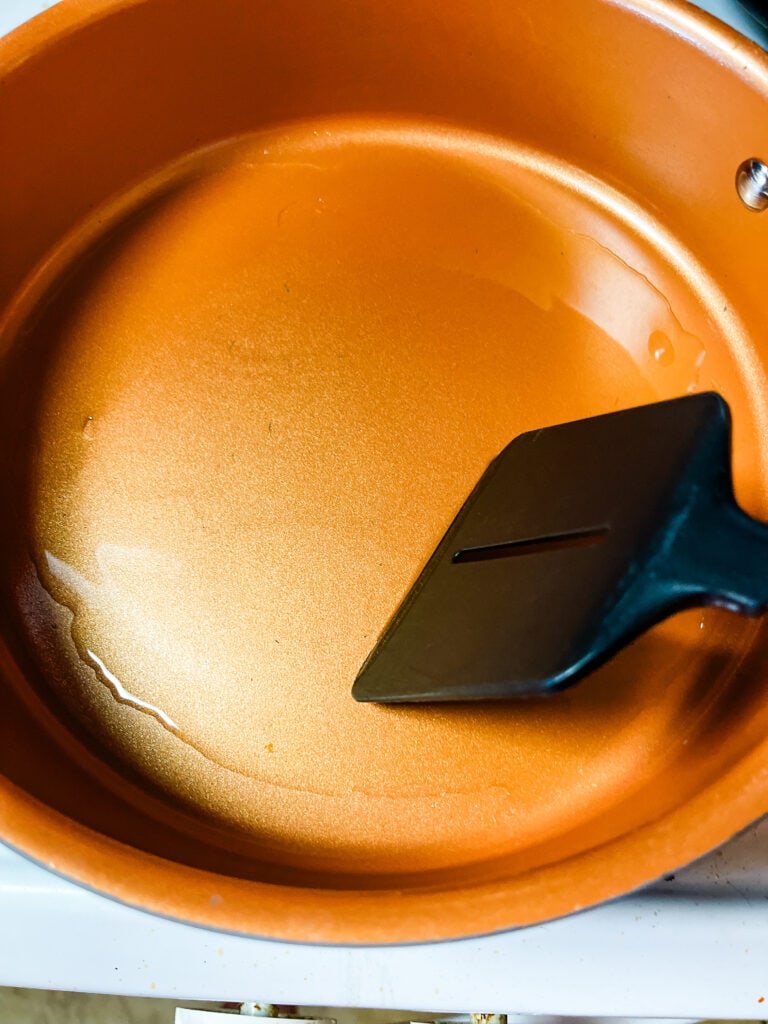 Spreading oil in the hot pan with a spatula.