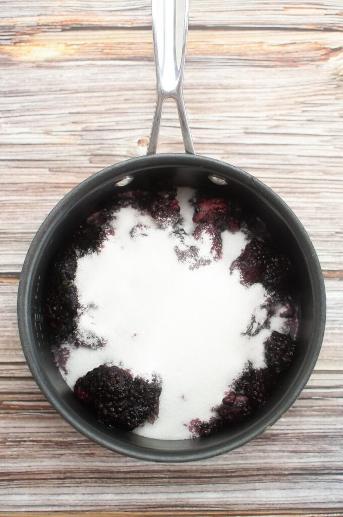Blackberries and sugar in the pan ready to cook.