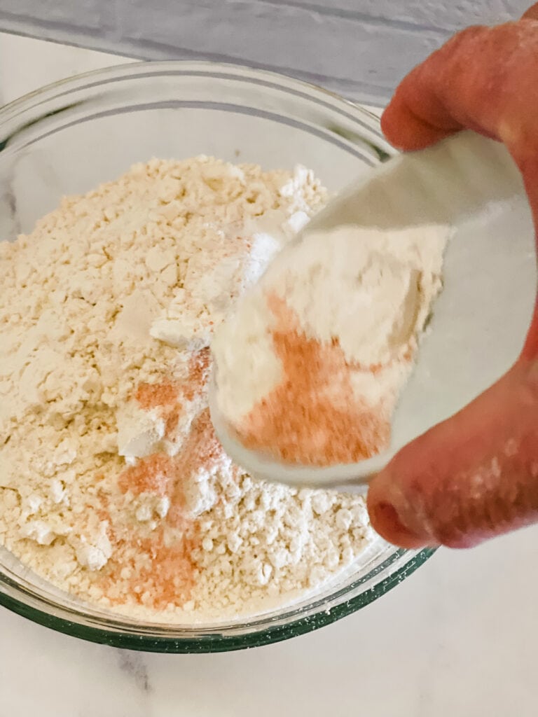 Adding the other dry ingredients to the measured flour.
