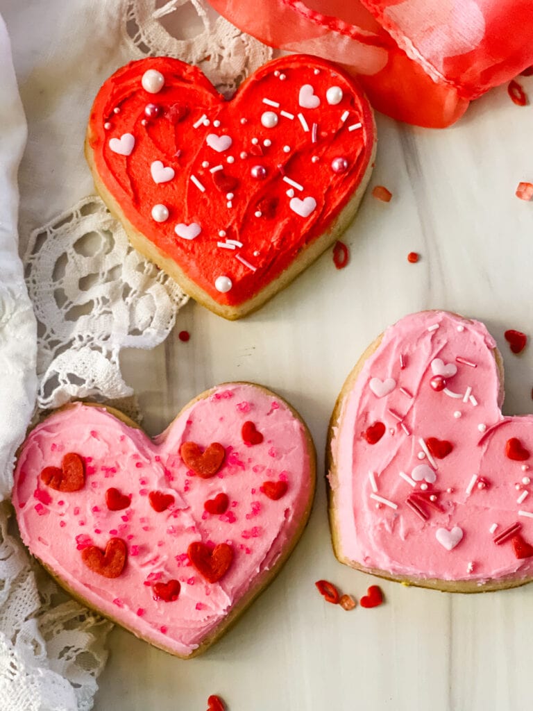 Three heart cookies decorated with buttercream icing.