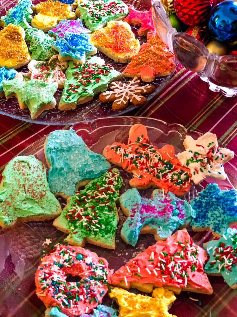 A couple of plates of christmas frosted sugar cookies.