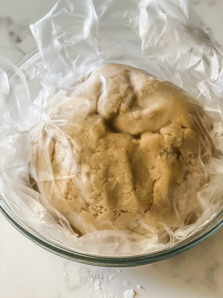 Covering the cookie dough with plastic and getting ready to refrigerate it.