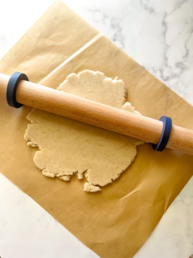 Rolling the dough with the wooden rolling pin.