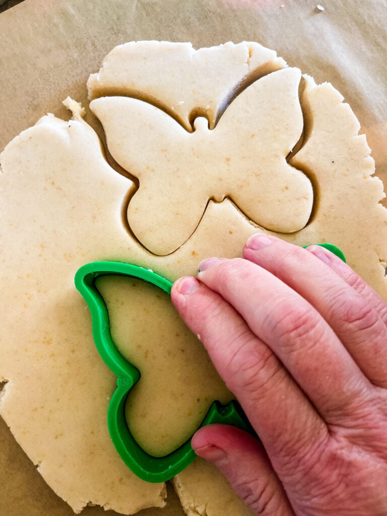 Showing how to cut out the cookies with a butterfly cutter. The top cookie has already been cut.