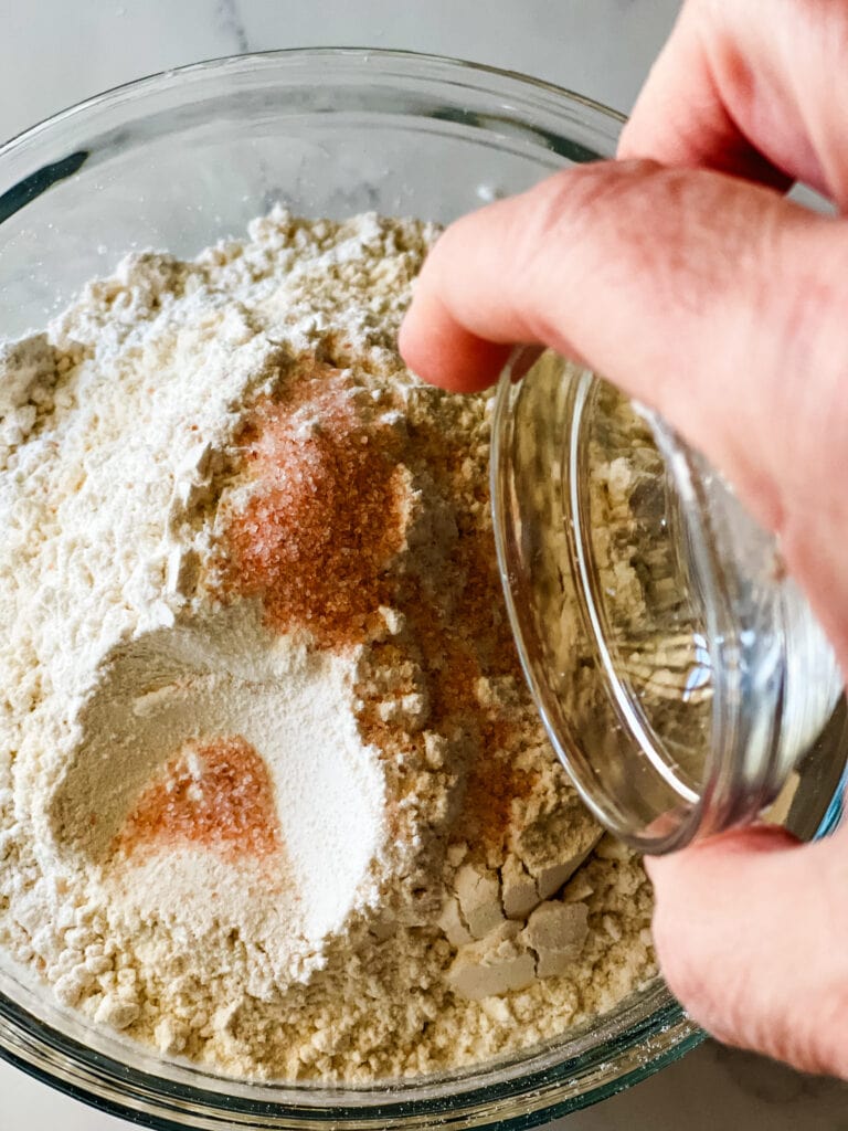 Adding the dry ingredients to a bowl.