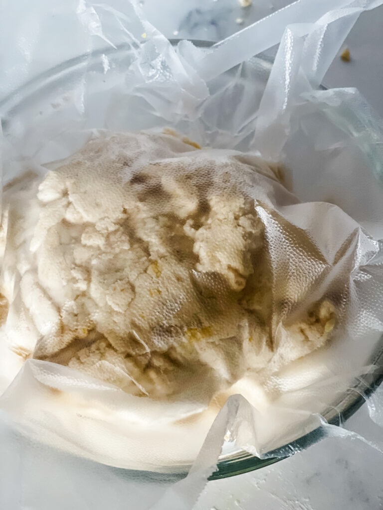 Covering the lemon cookie dough with plastic wrap.