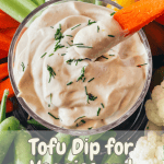 A bowl of tofu dip with a carrot dipping out a portion surrounded by various veggies and Pinterest text overlay.