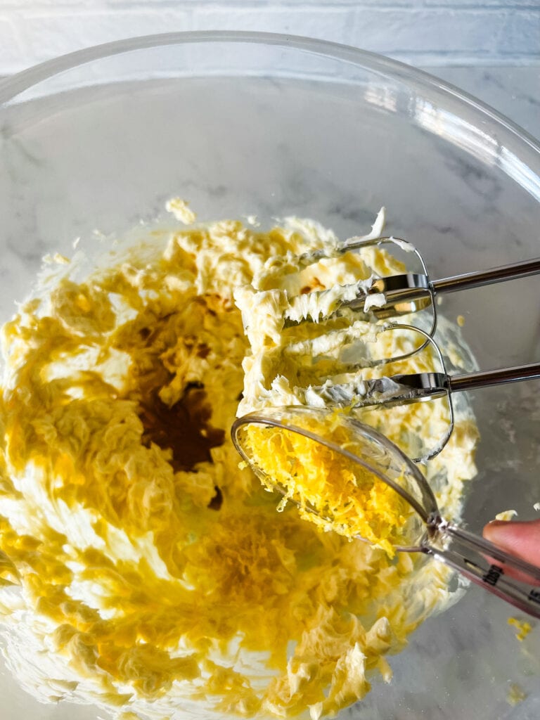 Adding the lemon zest to the lemon butter and shortening mixture.