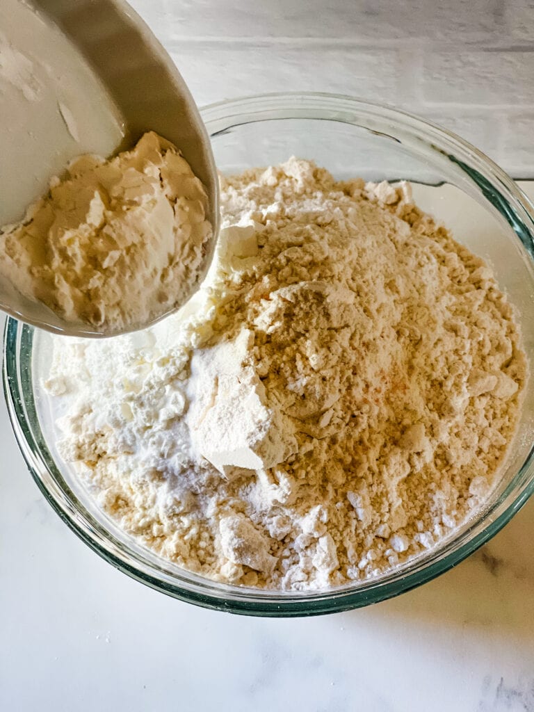 Adding dry ingredients to the flour.