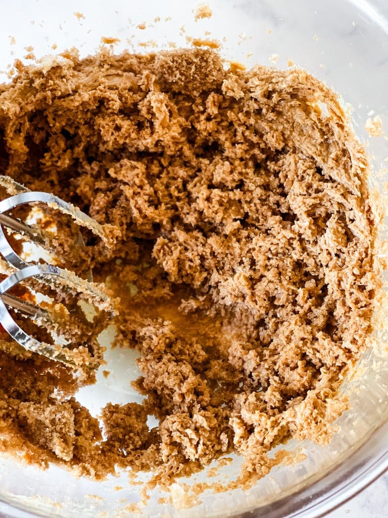 Mixing together the fats and sugars.