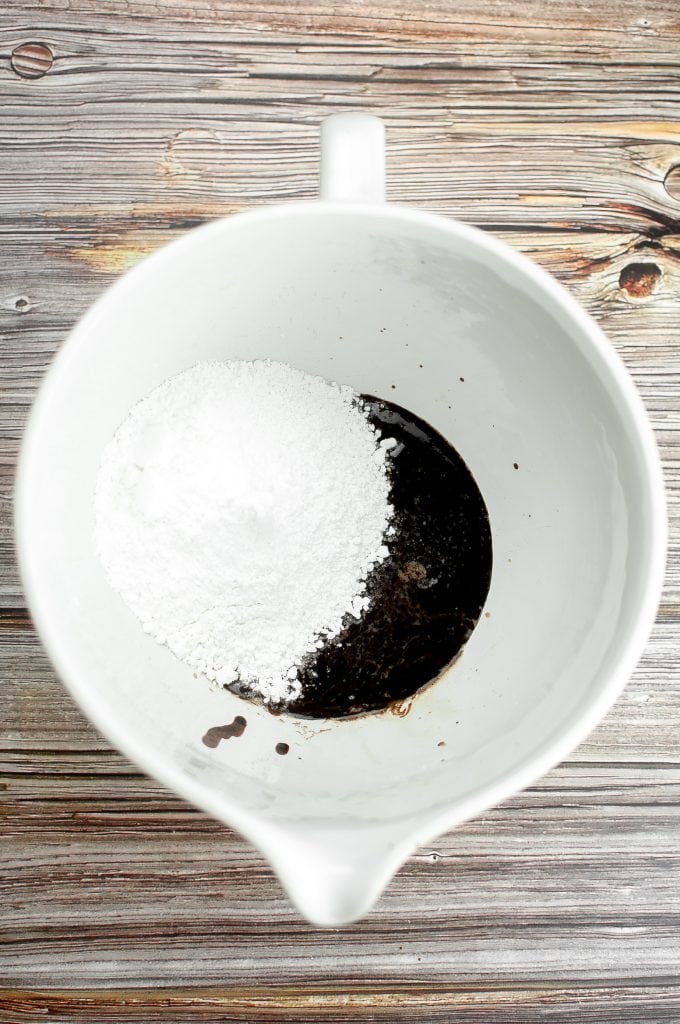 Adding the powdered sugar to the melted butter and cocoa.
