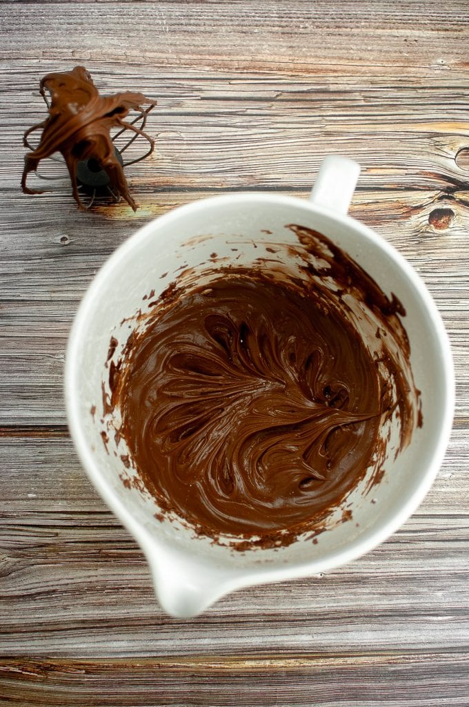 The chocolate frosting in the bowl has been mixed.
