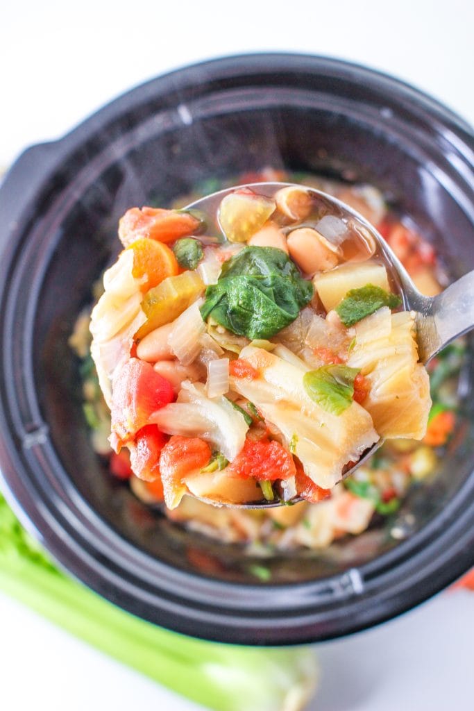 Ladling out the cooked minestrone soup. Celery stalk lower left.