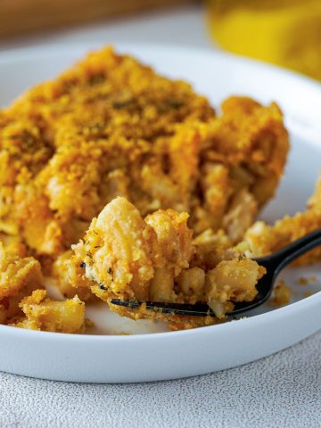 vegan mac and cheese on a plate with a forkful