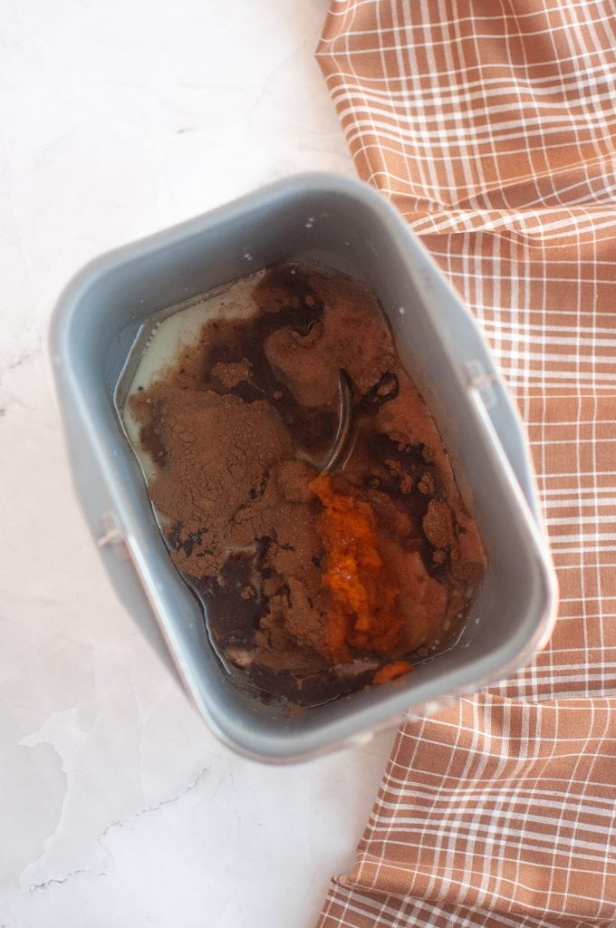 Placing the wet ingredientsfor bread machine pumpkin bread in the pan.