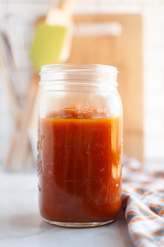 Jar of pumpkin jam with plaid napkin on the right.
