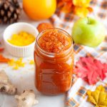 Jar of pumpkin jam surrounded by fall decor.