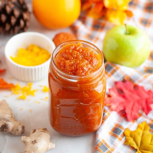 Jar of pumpkin jam surrounded by fall decor.