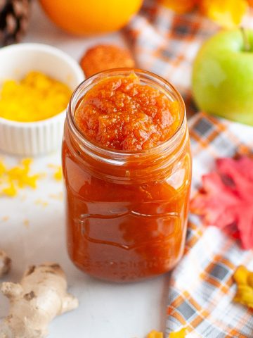 Jar of pumpkin jam surrounded by fall decor.