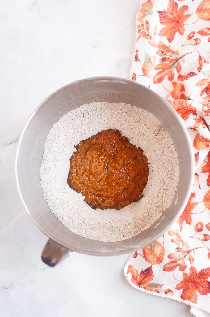 Placing the wet ingredients on top of the dry ingredients for vegan pumpkin cookies