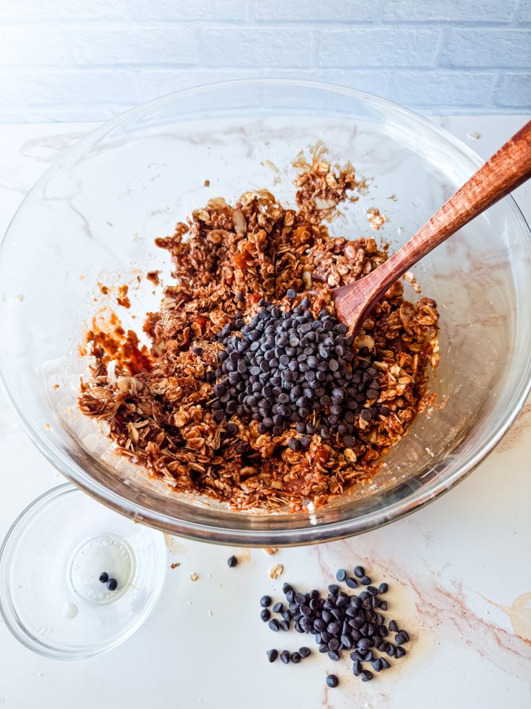 stirring vegan chocolate chips into the almond butter granola bar mixture