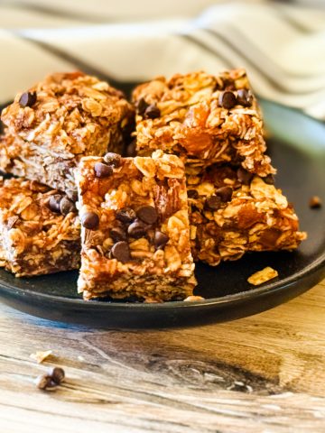 Oatmeal almond butter chocolate chip energy bars on a black plate.