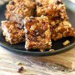 Oatmeal almond butter chocolate chip granola bars on a black plate.