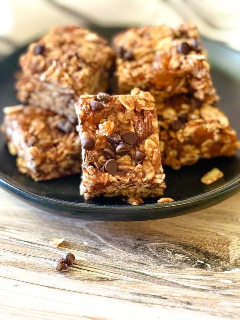 Oatmeal almond butter chocolate chip granola bars on a black plate.