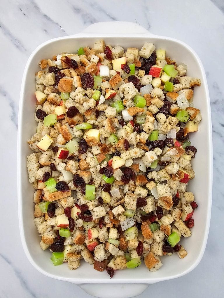Vegan stuffing mixture is in a white casserole dish ready to bake.